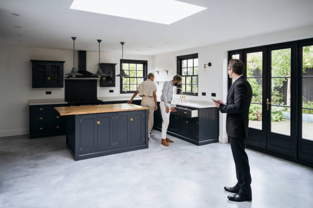 prospective home buyers examining features of luxury kitchen - home inspection imagens e fotografias de stock