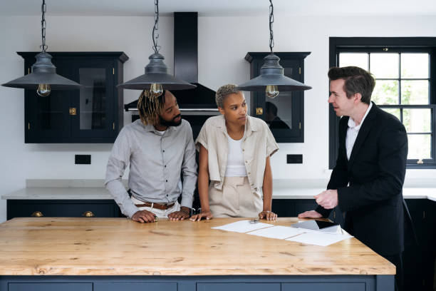 istock Estate agent and prospective buyers discussing paperwork 1328886196