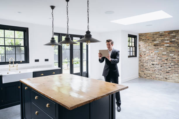 istock Male estate agent using digital tablet to photograph kitchen 1328886207