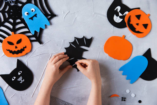 istock How to make decore for Halloween greetings and fun. Children art project. DIY concept. Step by step photo instruction. Step 1. Decorate bat wings 1328888292