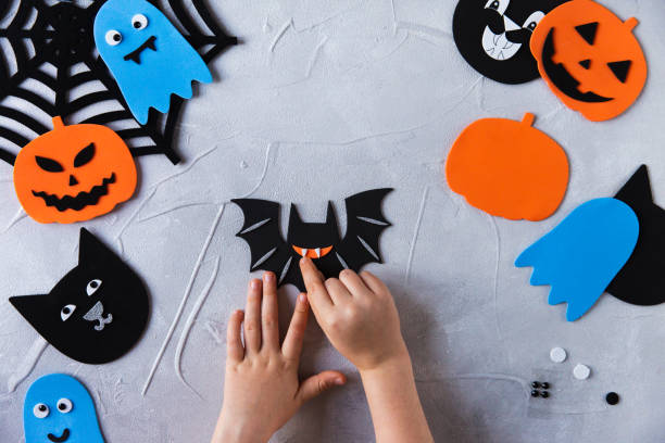 istock How to make decore for Halloween greetings and fun. Children art project. DIY concept. Step by step photo instruction. Step 3. Glued bat fangs 1328888316