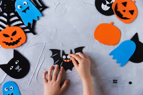 istock How to make decore for Halloween greetings and fun. Children art project. DIY concept. Step by step photo instruction. Step 4. Glued eyes 1328888322