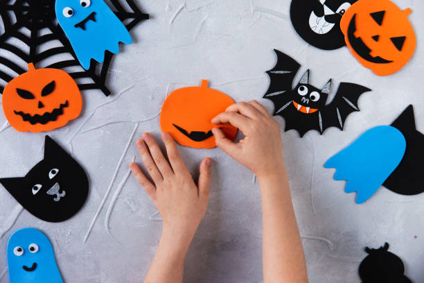 istock How to make decore for Halloween greetings and fun. Children art project. DIY concept. Step by step photo instruction. Step 1. Glue the mouth for the pumpkin 1328888355