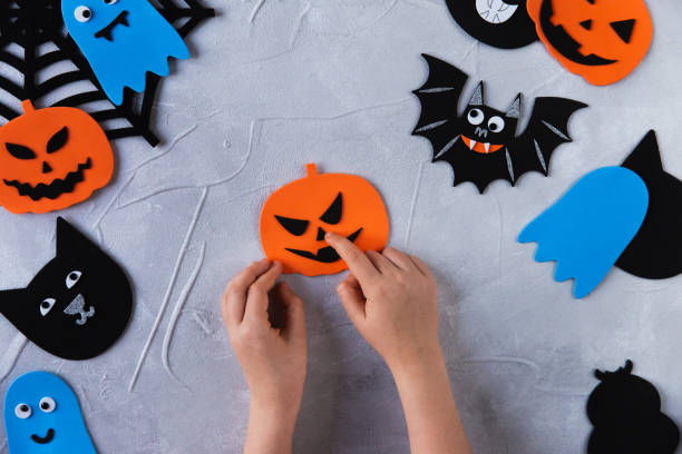 istock How to make decore for Halloween greetings and fun. Children art project. DIY concept. Step by step photo instruction. Step 3. Glue nose for the pumpkin 1328888357