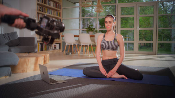 istock Sportswoman exercising on yoga mat at home. Making tutorial with camera 1328889297