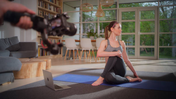 istock Sportswoman exercising on yoga mat at home. Making tutorial with camera 1328889306