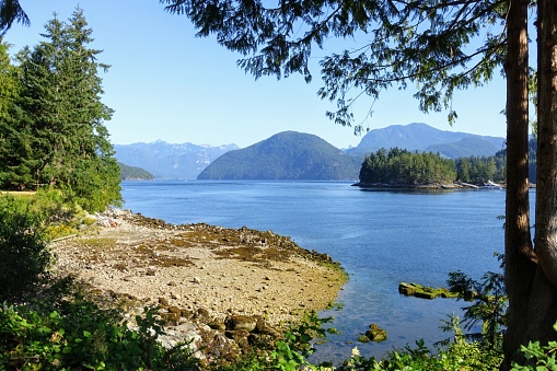 Spectacular ocean seascape of a beautiful blue ocean surrounded by islands covered in forest along the sunshine coast, British Columbia, Canada