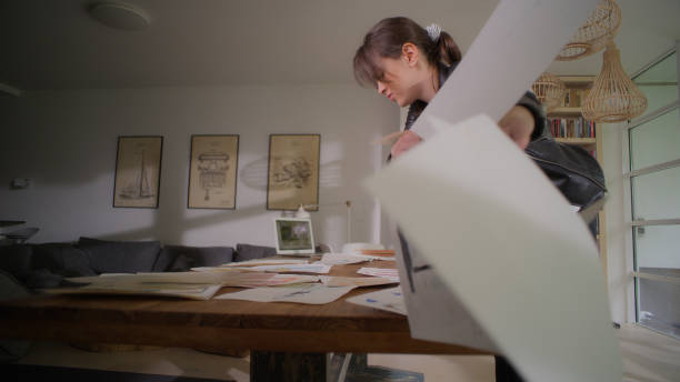 istock Frustrated female fashion designer at work. Picking projects and throwing them away 1328890182