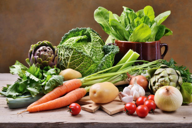 assortimento di verdure fresche su tavolo rustico in legno con tagliere e vecchia pentola. - minestrone foto e immagini stock