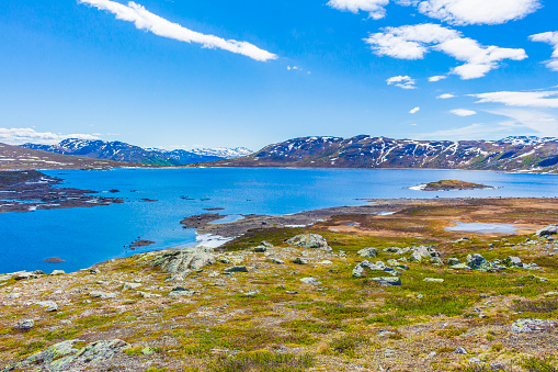 Amazing Vavatn lake panorama rough landscape view rocks boulders and mountains during summer in Hemsedal Norway.