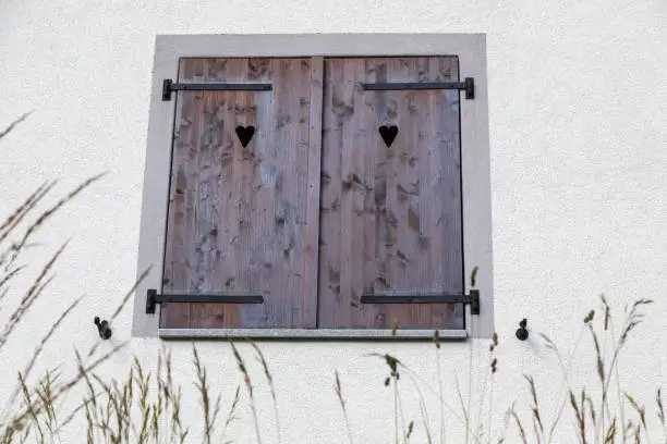 closed wooden shutters with heart-shaped holes