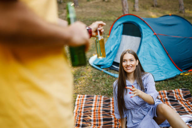 istock Young couple camping, drinking beer and having fun 1328893625