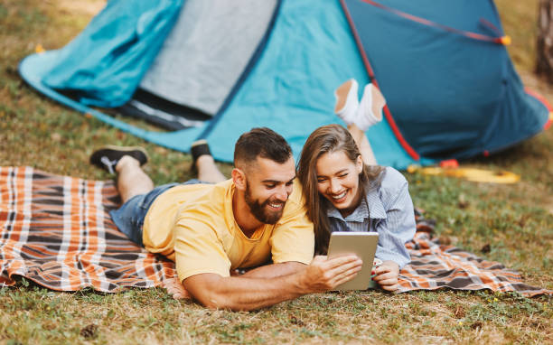 Romantic couple camping, resting and reading a book