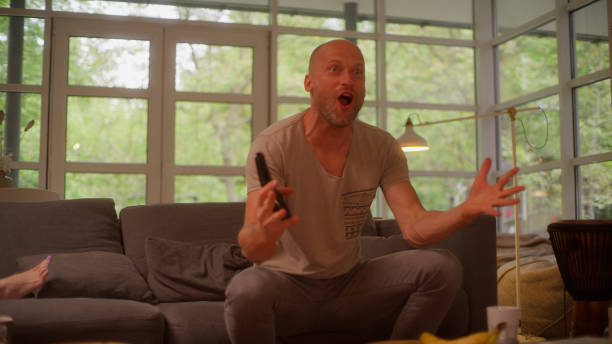 istock Man watching intense sports match. Big emotions on a couch 1328896620