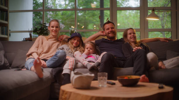 istock Watching tv at home. Family with three daughters spending time together. 1328896729