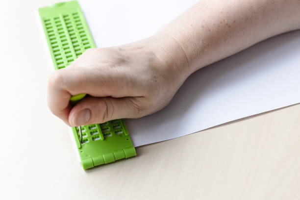 istock writing words in braille with slate and stylus 1328898203