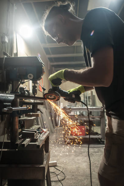istock Craftsman with electric grinder tool on steel structure in factory 1328899685