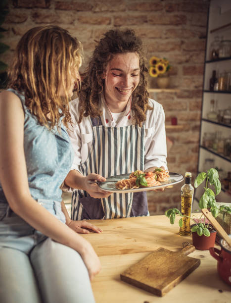 istock Playful young couple having dinner together. Eating spaghetti 1328900219