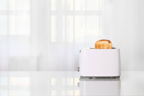 istock Toaster with slices of bread on the kitchen glass table 1328902449