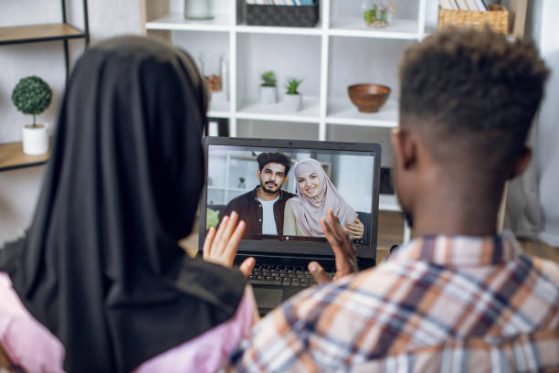 istock Young couple waving hands during video call with relatives 1328903684
