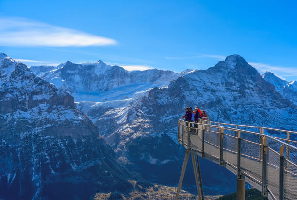 turistas tiram fotos no cliff walk, uma plataforma de visualização popular na primeira montanha em grindelwald, que oferece com vista alpina - swiss culture switzerland european alps rock - fotografias e filmes do acervo