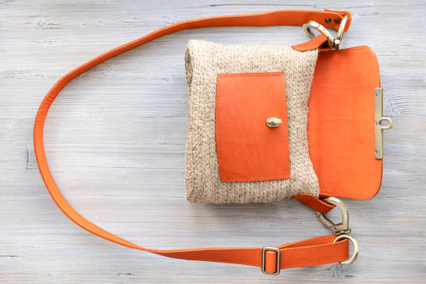 top view of open hand-knitted cross body bag top view of open hand-knitted casual cross body bag with orange leather cover on gray wooden table shoulder bag stock pictures, royalty-free photos & images