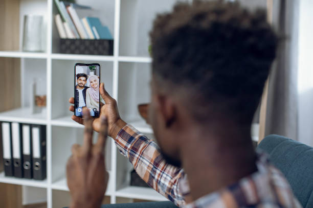 istock Black man using mobile for video call with muslim couple 1328904272