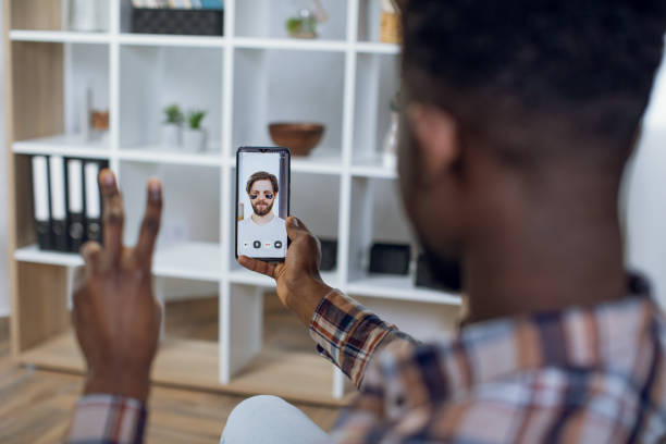 istock African man talking with caucasian friend during video call 1328905337