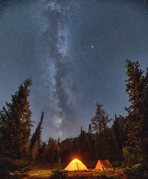 Photo of Camping tents with milky way in the night sky on campsite in autumn forest at national park