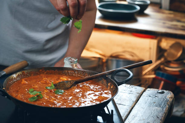 istock Preparing Indian Chicken Curry in Domestic Kitchen 1328906519