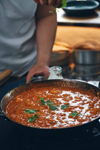 istock Preparing Indian Chicken Curry in Domestic Kitchen 1328906575