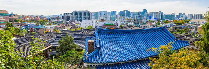 Aerial panoramic view across the crowded rooftops of central Seoul and Bukchon Hanok village to the modern skyscraper skyline of downtown in the heart of South Korea’s vibrant capital city.