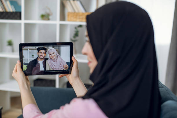 istock Muslim woman talking with relatives through video call 1328907002