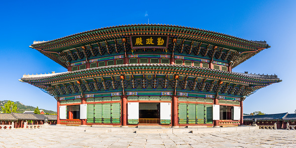 Ornate wooden pavilion overlooking a flagstone courtyard at Gyeongbokgung in the heart of Seoul, South Korea’s vibrant capital city.