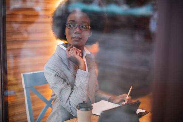 istock Business woman sitting at cafe with tablet and documents 1328909199