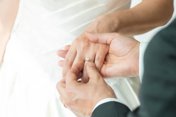 istock Midsection Of Couple Exchanging Wedding Ring 1328919309