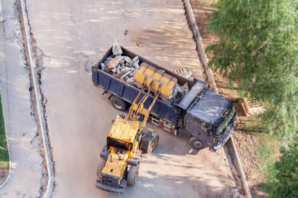 istock Aerial drone view excavator loading the tipper truck at the construction site under the tree 1328920024