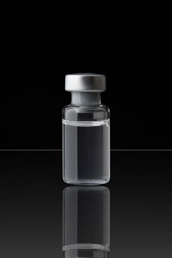 Medical vial on black background