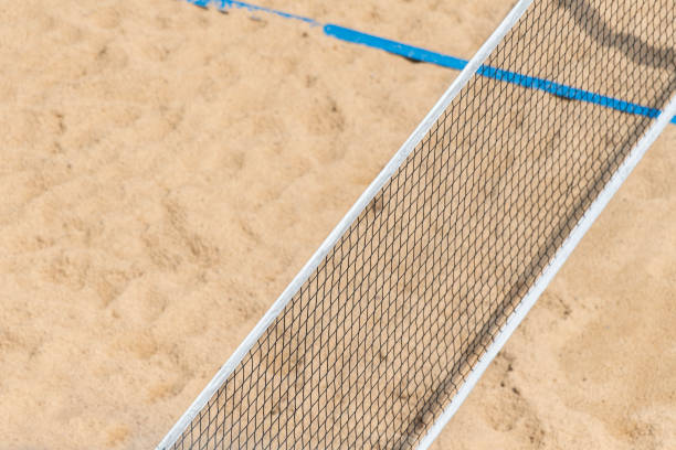 beachvolleyball und beachtennisnetz auf dem hintergrund von sand. sommersportkonzept - strand volleyball stock-fotos und bilder