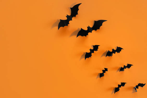 istock Halloween card with black bats on orange background. Banner for congratulations or invitation. 1328932785