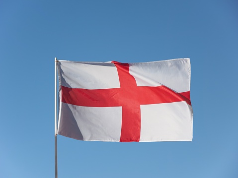 the English national flag of England, UK isolated over blue sky