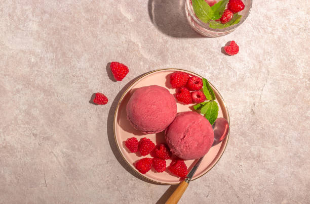 istock Raspberry ice cream with fresh raspberries and mint on pink plate over pink background. Trendy long shadows, sunny light. 1328949701