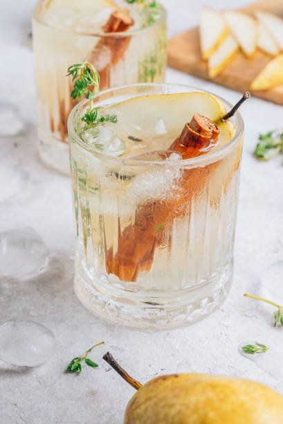 istock Festive summer spicy cocktail with pears and thyme on light beige background. 1328949713