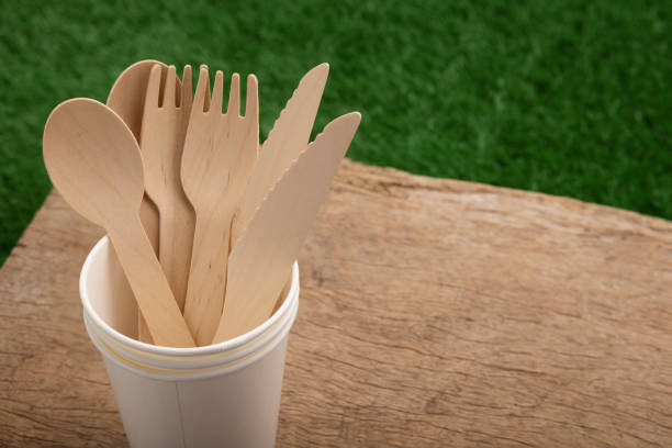 istock Wooden spoon and fork with knives in paper cup  , disposable tableware on a wooden table background , Eco-friendly materials 1328952633