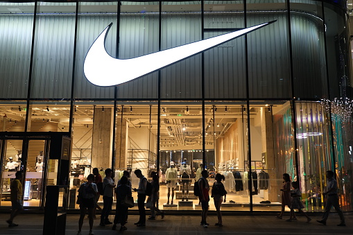 Shanghai.China-July 2021: Large NIKE store at night with many people‘s silhouette. American sports brand
