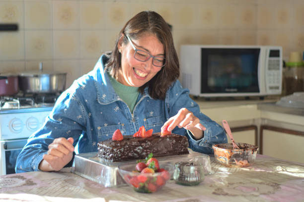 istock Mature woman preparing a chocolate cake at home 1328957544