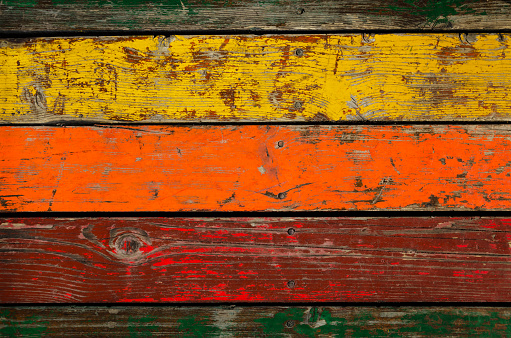 Multicolored wooden background. Planks are painted with different colors, but weathered and partially peeled.