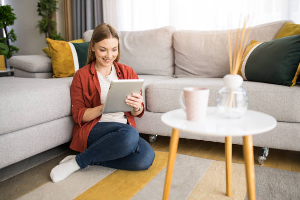 istock Cheerful young woman searching the internet on digital tablet. 1328963244
