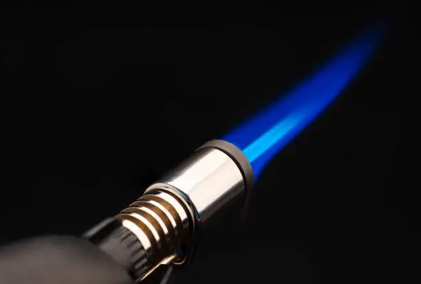 Close up of Blue flame from a gas torch burner on black background