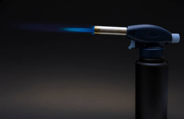 istock Blue flame from a gas torch burner on black background 1328963308